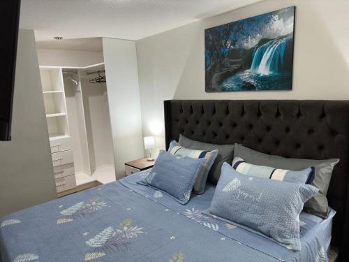 利马595 Departamento en Chorrillos的一间卧室配有一张带蓝色棉被和枕头的床