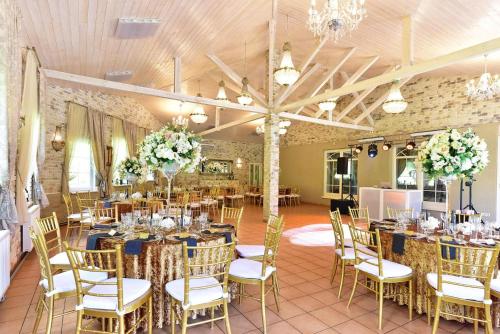 ToliejaiVila "Santa Barbara"的宴会厅配有桌椅和鲜花