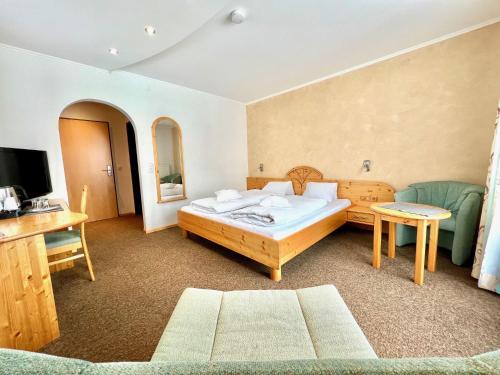 德弗雷根谷地圣雅各布加尼汉堡酒店的一间卧室配有一张床、一张沙发和一台电视。