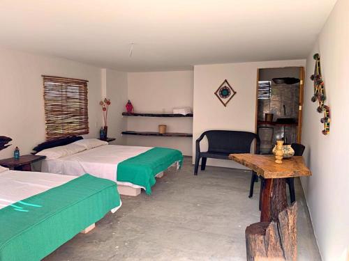 里奥阿查La Triada的一间卧室配有两张床、一张桌子和一把椅子
