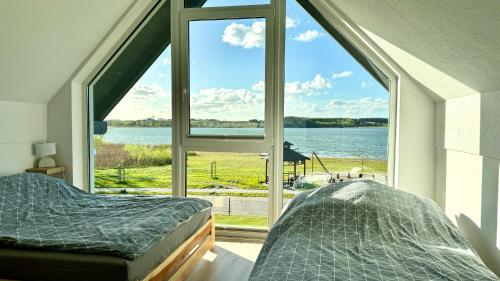 KiedrowiceDomki nad jeziorem u Izy的一间卧室设有大窗户,享有水景