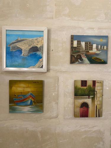 比尔古Birgu Studio Maisonette的墙上四幅画,上面有画作