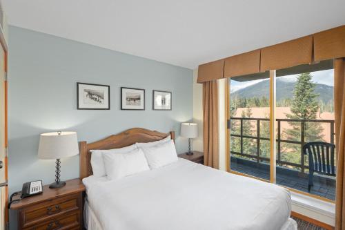 惠斯勒Cascade Lodge的一间卧室设有一张床和一个大窗户