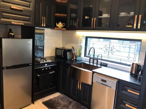 Egmont VillageTiny Home Luxury Farm Escape的厨房配有黑色橱柜和不锈钢冰箱