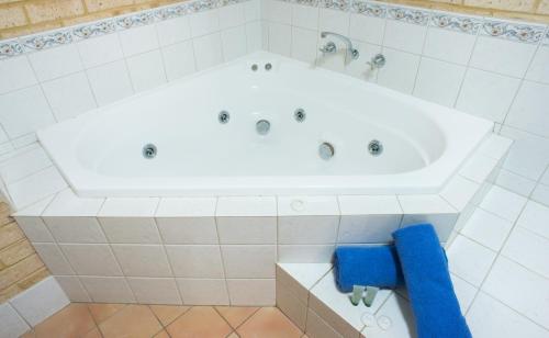卡尔巴里卡尔巴里棕榈度假酒店的浴室内设有大型白色浴缸。