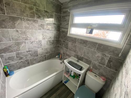 威瑟恩西348 Golden Sands的带浴缸、卫生间和窗户的浴室