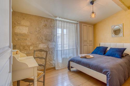 阿维尼翁La Chapelle du Miracle的一间卧室配有一张床、一张书桌和一个窗户。