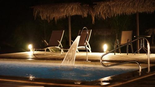 梅塞德斯Complejo Enrique Joaquin的一个带椅子的游泳池以及一个喷泉