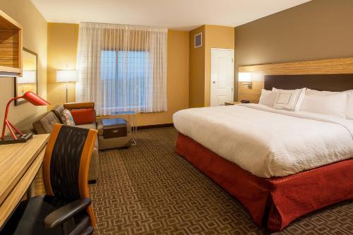 布卢明顿TownePlace Suites by Marriott Minneapolis near Mall of America的酒店客房带一张大床和一把椅子