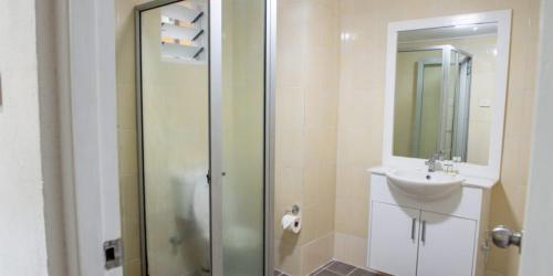 苏瓦Yatulau Hotel and Conference的一间带玻璃淋浴和水槽的浴室