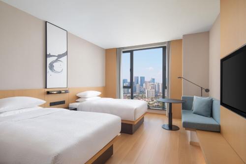 成都成都高新万枫酒店的酒店客房设有两张床和一台平面电视。