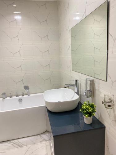 阿克拉Century Premier Suite的浴室配有白色浴缸和水槽