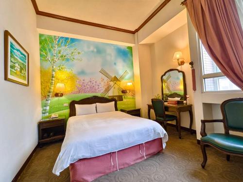 罗东镇东方商务大饭店的一间卧室,配有一张床和风车画