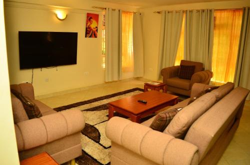 KakamegaMusundi Luxury Homes的客厅配有2张沙发和1台平面电视