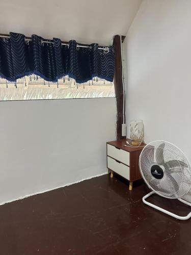 爱妮岛HIRAYA Camp Site - FREE use of SCOOTER for NIPA HUTS的客房设有风扇、梳妆台和窗户。