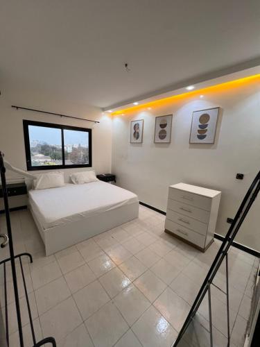 达喀尔Le duo by sdm的卧室配有白色的床和窗户。