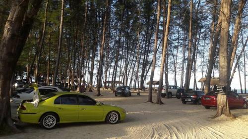 巴佐Chalet Barokah Resort, Bachok的绿色的汽车停在一个树木繁茂的停车场