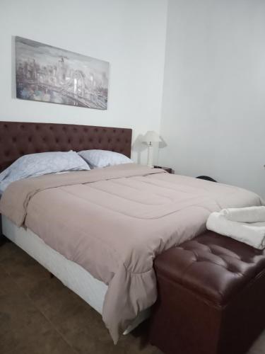 埃斯特角城Chiquense的一间卧室配有一张大床和棕色的软木床头板