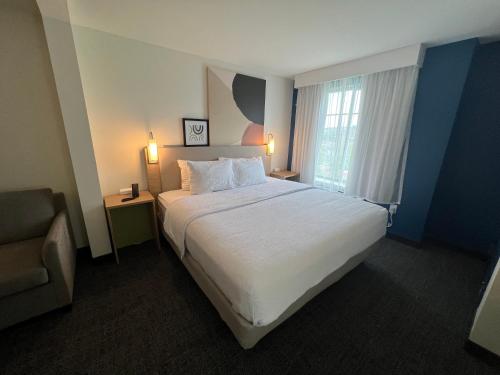 蒙哥马利Spark by Hilton Montgomery的酒店客房带一张大床和一把椅子