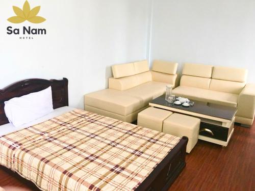 Thương Xà (2)Khách sạn Sa Nam Cửa Lò的客房设有床、沙发和桌子。