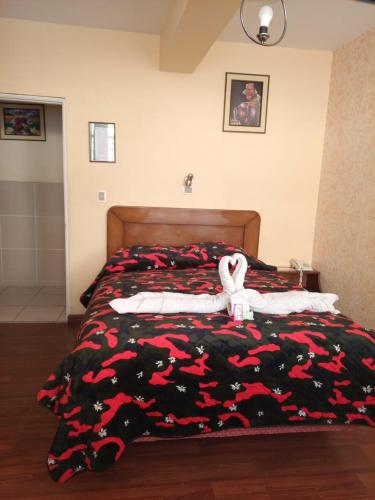 拉巴斯Hotel Lizarraga的卧室里设有一张床,上面有一只动物