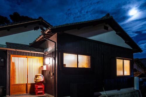 直岛町Naoshima Juju Art House　直島ジュジュアートハウス的夜晚有前门的房子