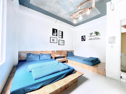 吉婆岛Domik Homestay - Cát Bà的一间卧室配有蓝色的床和木制床架