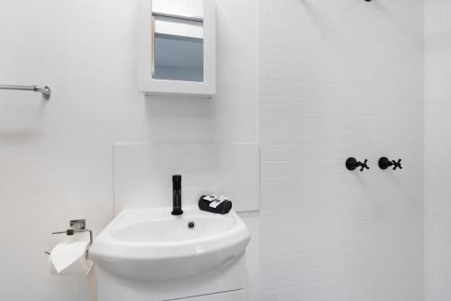 RathminesParadise Palms Caravan Park的白色的浴室设有水槽和镜子