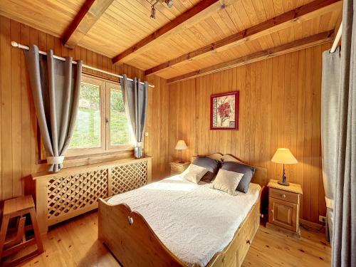 孔布卢Chalet Combloux, 5 pièces, 8 personnes - FR-1-560-32的木制客房内的一间卧室,配有一张床