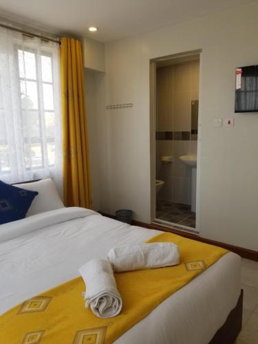 内罗毕7 Days Holiday Inn的一间卧室配有带毛巾的床