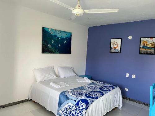拉斯特拉纳斯Hotel brisa mar的一间卧室配有一张蓝色墙壁的床