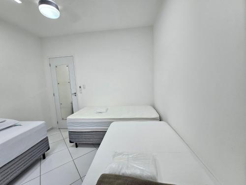 里约热内卢Quarto Privativo em Condominio的白色的客房配有两张床和镜子