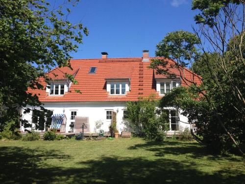NeuenkirchenFerienwohnung in Vieregge mit Großem Garten的一座白色的大房子,有橙色的屋顶