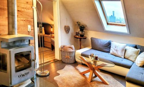 巴特哈尔茨堡Komfortwohnung ATELIER LOTUS - mit 3 SZ的客厅配有蓝色的沙发和燃木炉。