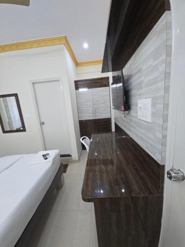 班加罗尔Hotel SnV Inn的一间卧室配有一张床和一台电视。