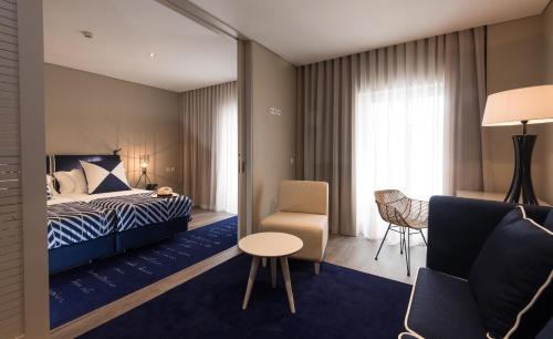 蓬塔德尔加达Hotel Casa Hintze Ribeiro的配有一张床和一把椅子的酒店客房
