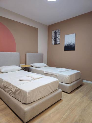 地拉那Center Cozy Nest的一间设有两张床和一张桌子的房间