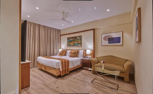 孟买Regent Hotel Andheri的配有一张床和一把椅子的酒店客房