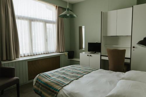 卡斯特尔莱Hotel Kempenrust的卧室配有床、椅子和窗户。