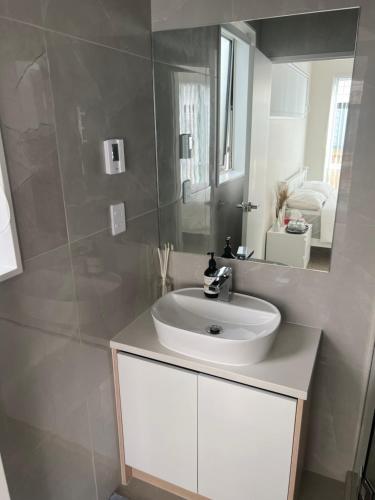 奥克兰Private Ensuite for singles or couples的浴室设有白色水槽和镜子