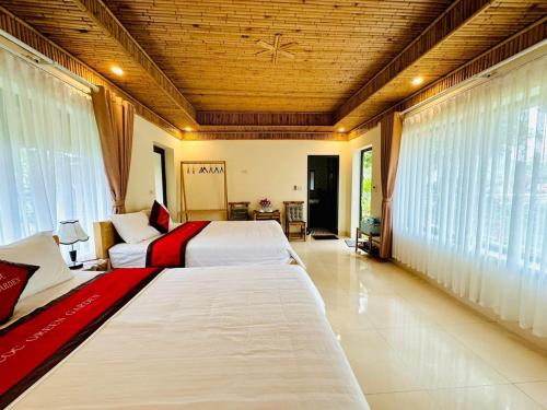 宁平Tam Coc Green Garden Bungalow的大型客房设有2张床和窗户。