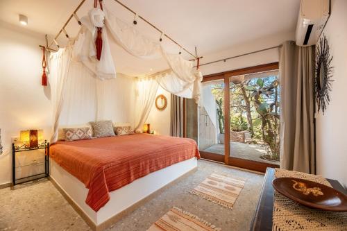 埃斯普霍斯El Dorado的一间卧室设有一张天蓬床和一个阳台