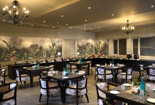 提喀迪Blanket Days Resort and Spa的一间带桌椅的餐厅,以及一幅大画