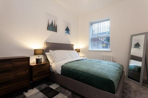 博尔顿Fantastic 1 bedroom apartment in Bolton的一间卧室配有一张床、梳妆台和镜子