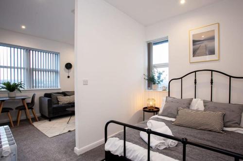 博尔顿Modern 1 Bedroom Apartment in Bolton的一间卧室设有一张床和一间客厅。