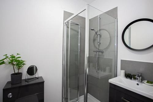博尔顿Modern 1 Bedroom Apartment in Bolton的一间带玻璃淋浴和水槽的浴室