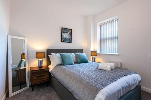 博尔顿Modern 2 Bedroom Apartment in Bolton的一间卧室配有一张大床和镜子