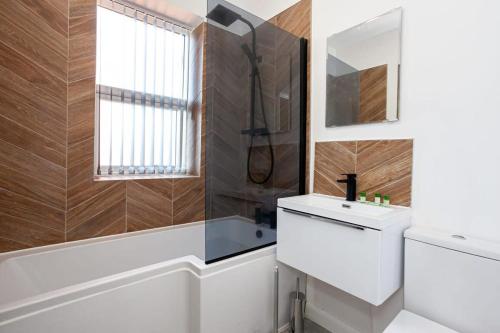 博尔顿Modern 2 Bedroom Apartment in Bolton的一间带卫生间、水槽和窗户的浴室