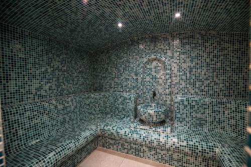 斯特鲁加Dishli Hotel & Spa的带浴缸和卫生间的瓷砖浴室