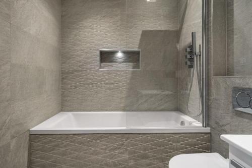伊斯特雷格Central Eastleigh 1 Bedroom Apartment的带浴缸和卫生间的浴室。